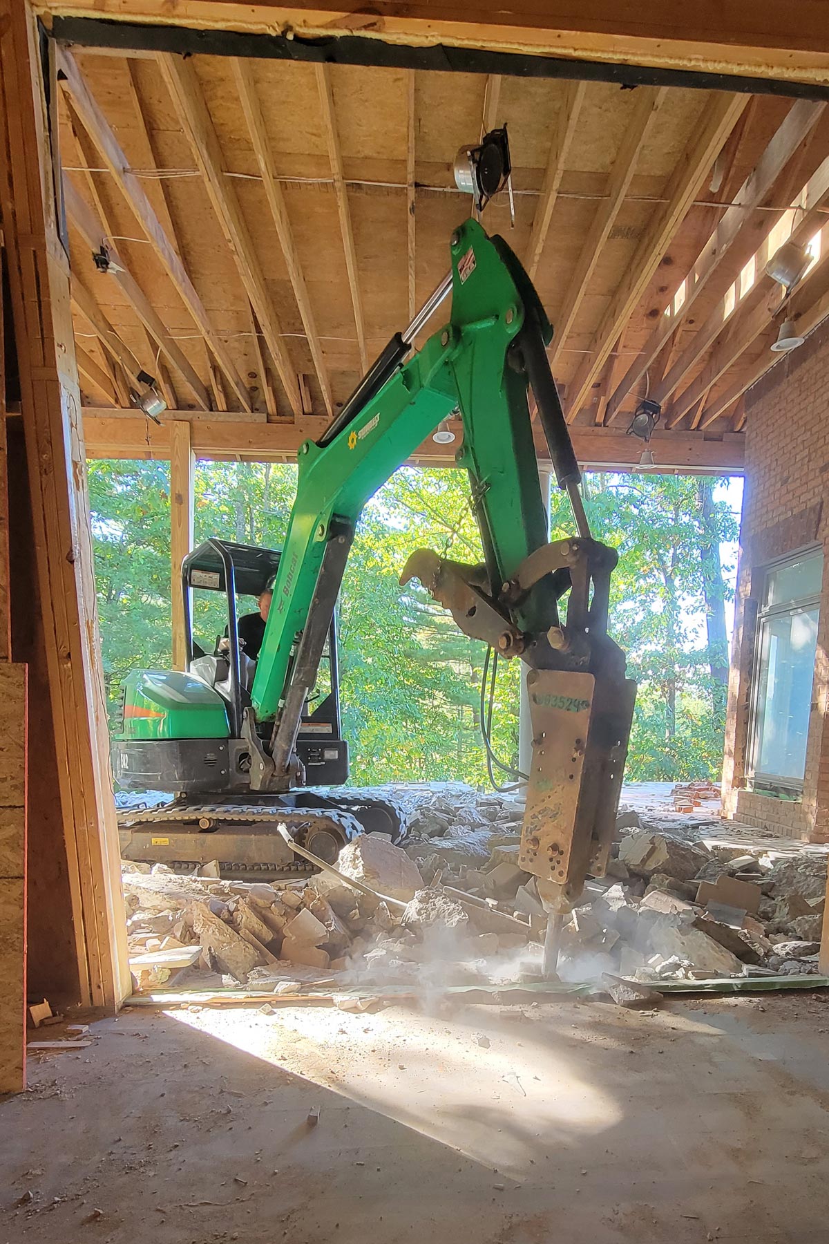 Using the bobcat to jackhammer the old, unstable patio