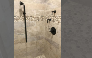 Bathroom renovation with river rock detail in wall tile