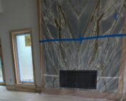 Luxury, bookmatched granite fireplace surround, blue-gray stone with bold white and brown veining