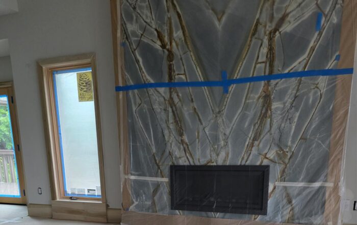 Luxury, bookmatched granite fireplace surround, blue-gray stone with bold white and brown veining