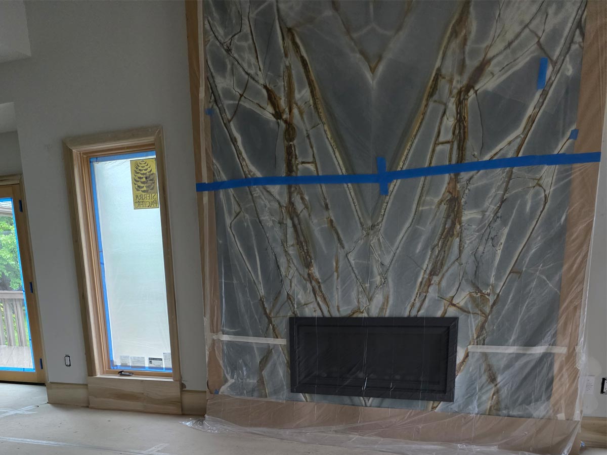 Luxury, bookmatched granite fireplace surround, blue-gray stone with bold white and brown veining