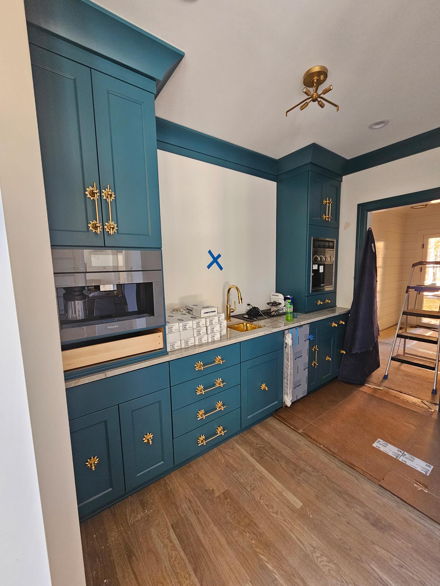 Installation of painted butler’s pantry cabinetry in a teal blue with aqua undertones Installation of painted butler's pantry cabinetry in a teal blue with aqua undertones
