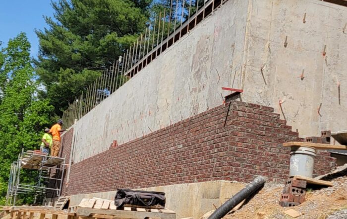 Mountain Remodeling of WNC tackles huge retaining wall of complex, sloped mountain lot to add expansive stone patio