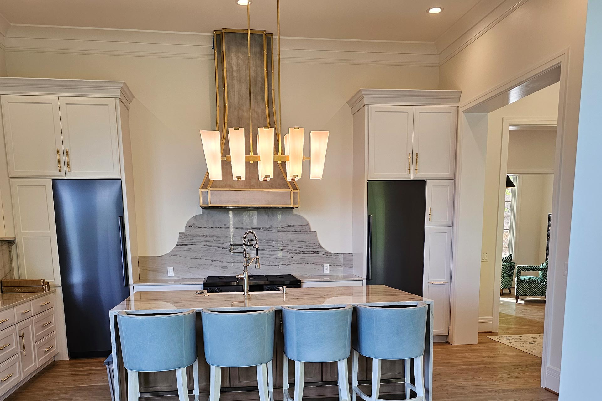 Relocated kitchen in reverse floorplan mountain home with featured hood vent and fridge and freezer towers flanking hood vent Relocated kitchen in reverse floorplan mountain home with featured hood vent and fridge and freezer towers flanking hood vent